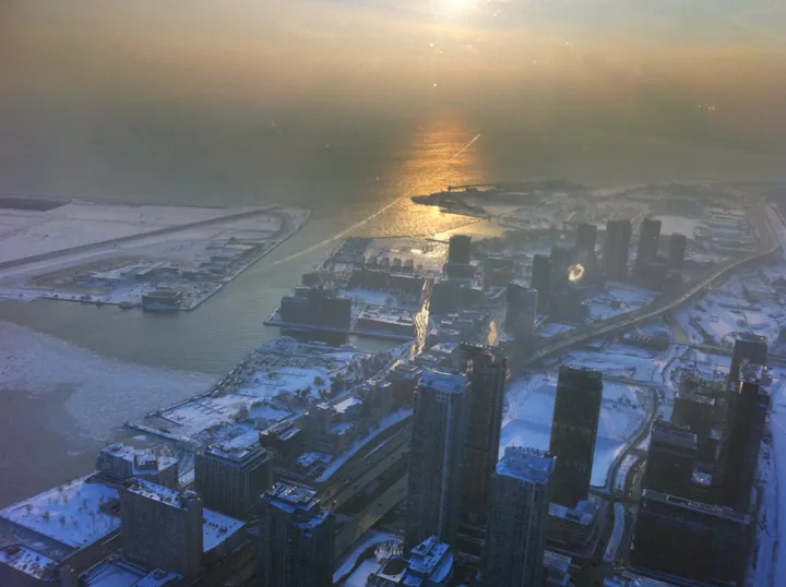 Snow-covered Toronto skyline at golden hour from the CN Tower observation deck
