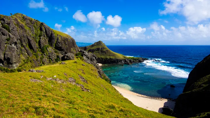 Lush green cliffs meeting turquoise waters on Sabtang Island